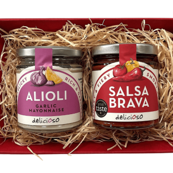 Two jars of Spanish salsas from Delicioso: Alioli and Salsa Brava, shown in a red gift tray with wood wool